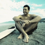 坐在沙滩休息的冲浪男